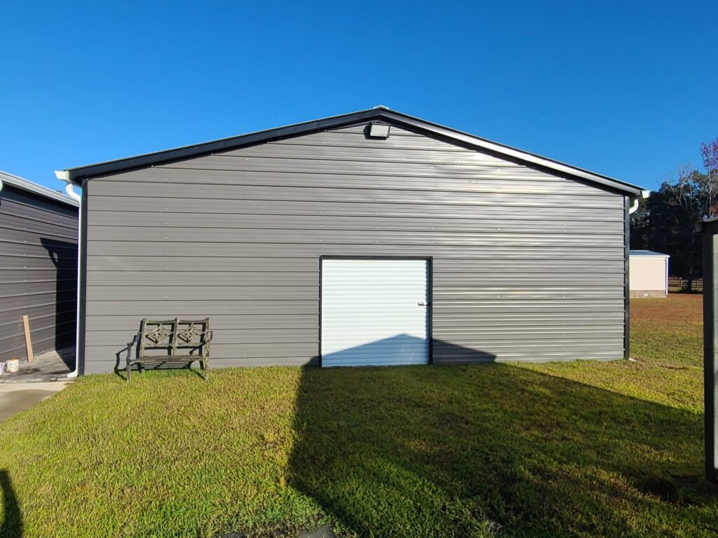 A large building with a bench in the grass.