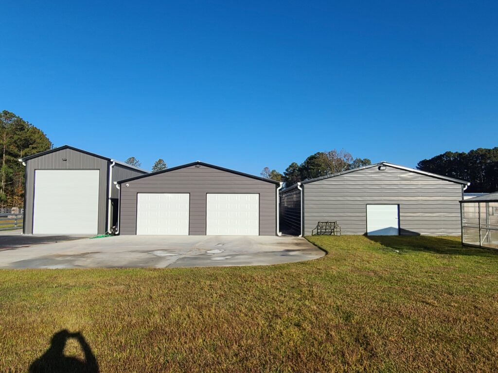 A group of three garage doors in the middle of a field.