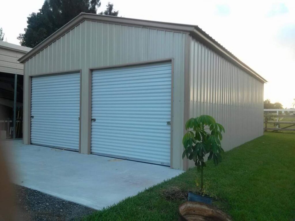 A large metal building with two doors and a plant.