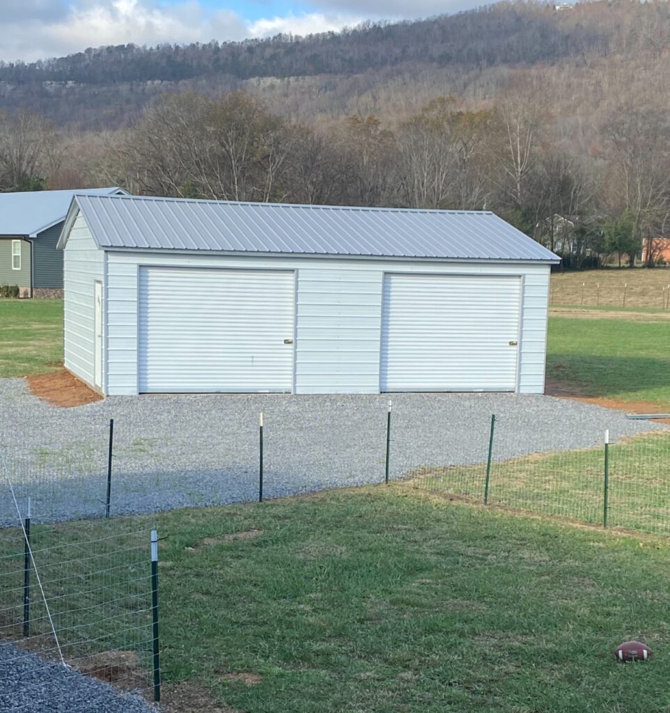 A white garage with two doors on the side.