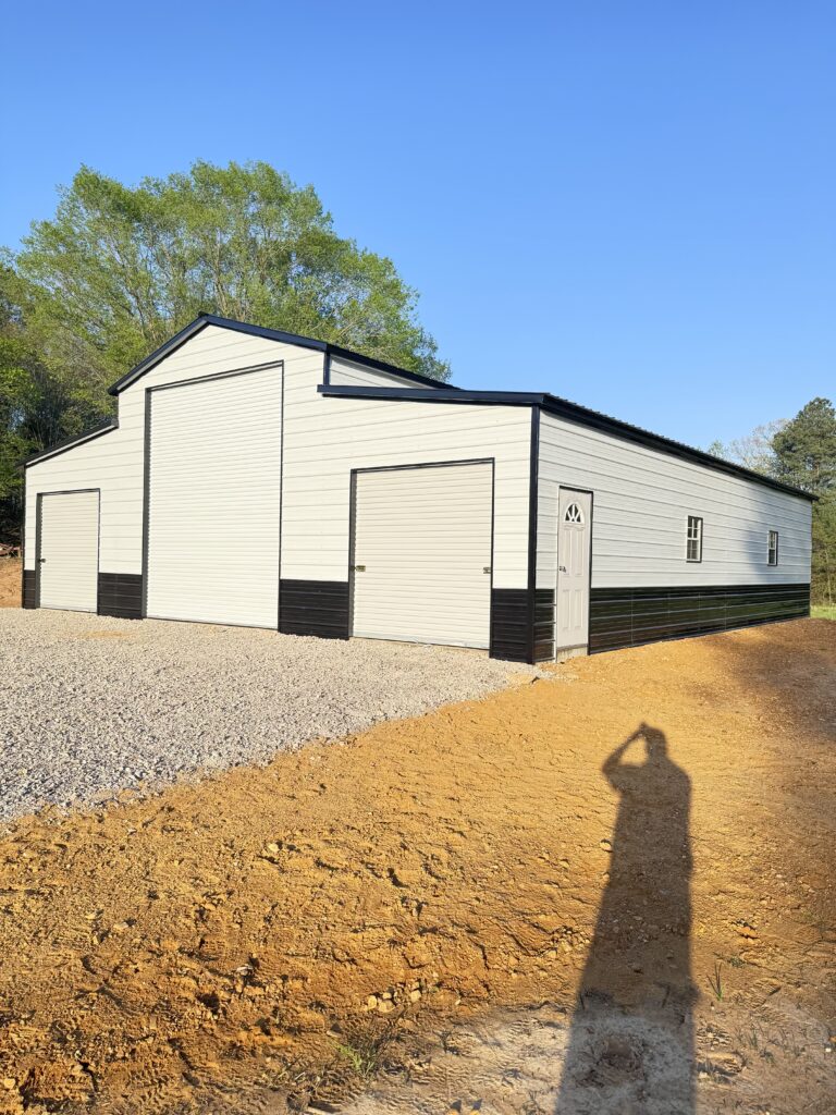 A metal barn with three garage doors and a side door.