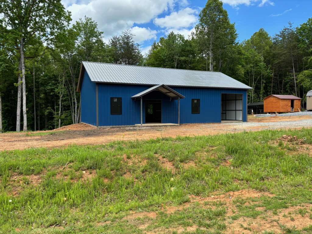 A blue metal building surrounded by trees.