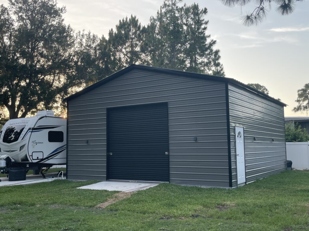 A gray metal building with a black garage door.